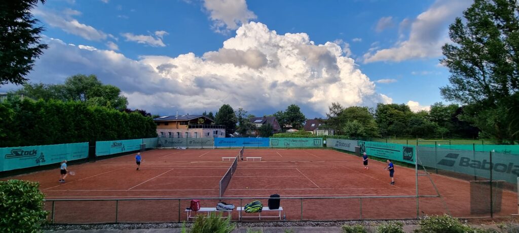 Ein Tennisplatz mit vier Männern, die ein Match spielen.