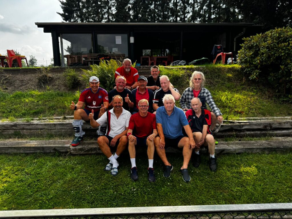 Einige männliche erwachsene Mitglieder der Tennisfreunde Ahrensfelde e.V., sitzend auf einer Treppe.