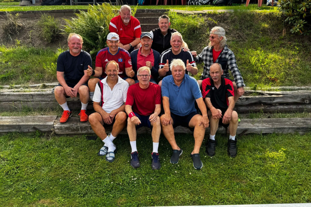 Einige männliche erwachsene Mitglieder der Tennisfreunde Ahrensfelde e.V., sitzend auf einer Treppe.